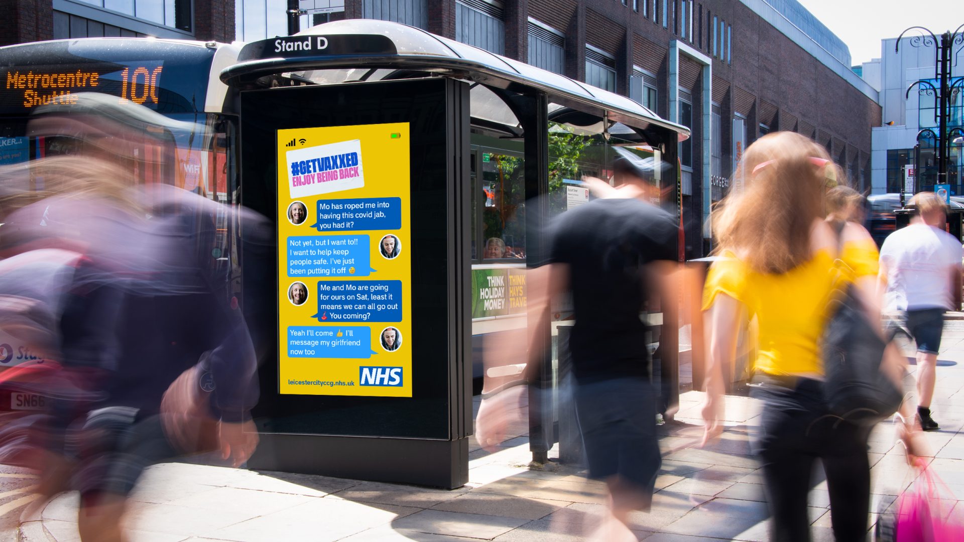 A get vaxxed NHS out of home advertising poster next to a bus stop