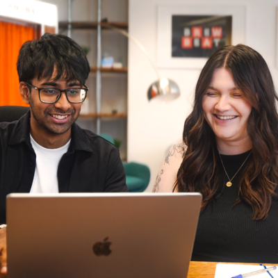 Designer, Tarren, and Senior Designer, Sarah, reviewing work on laptop