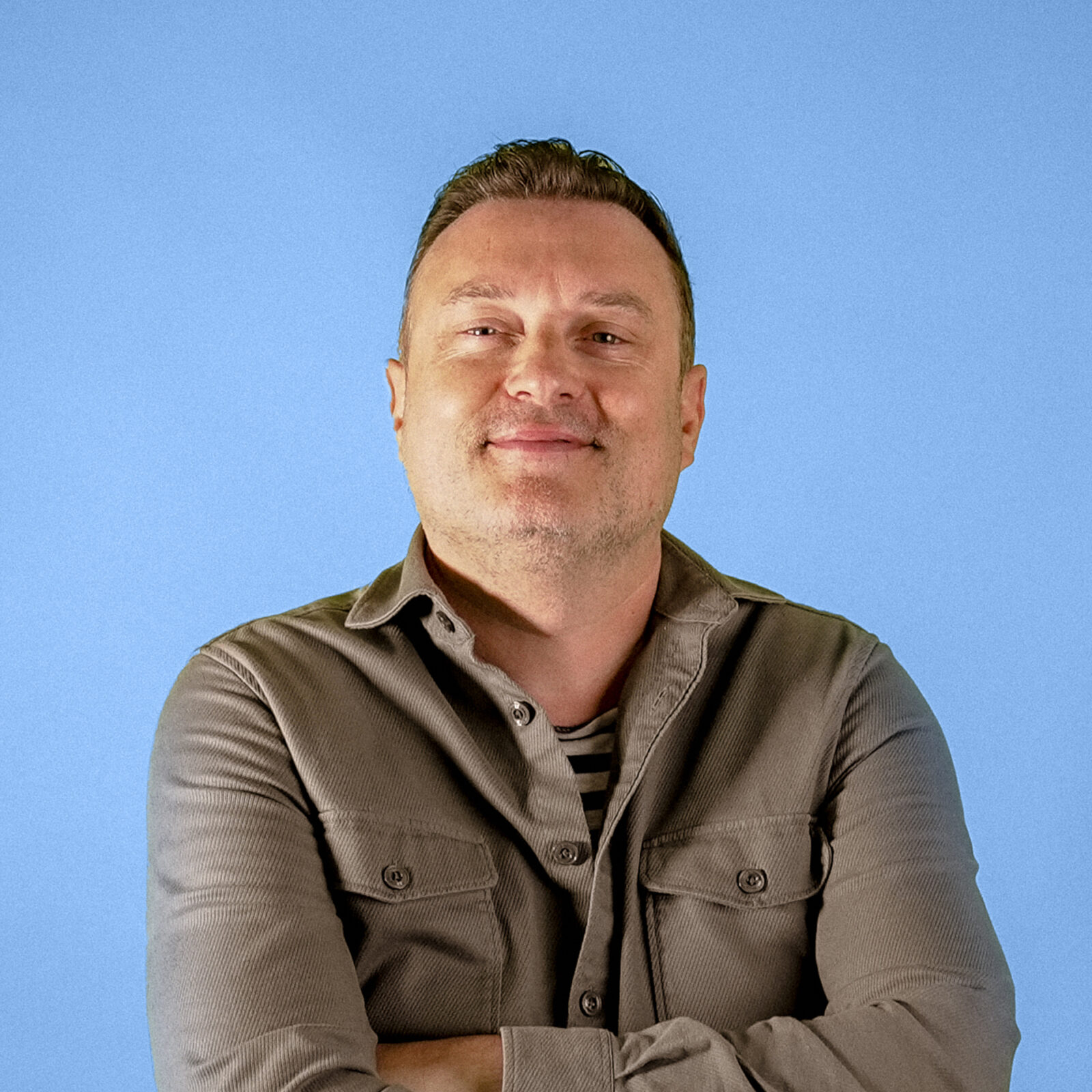 Headshot of Joe Nixon, Founder & Director, on blue background